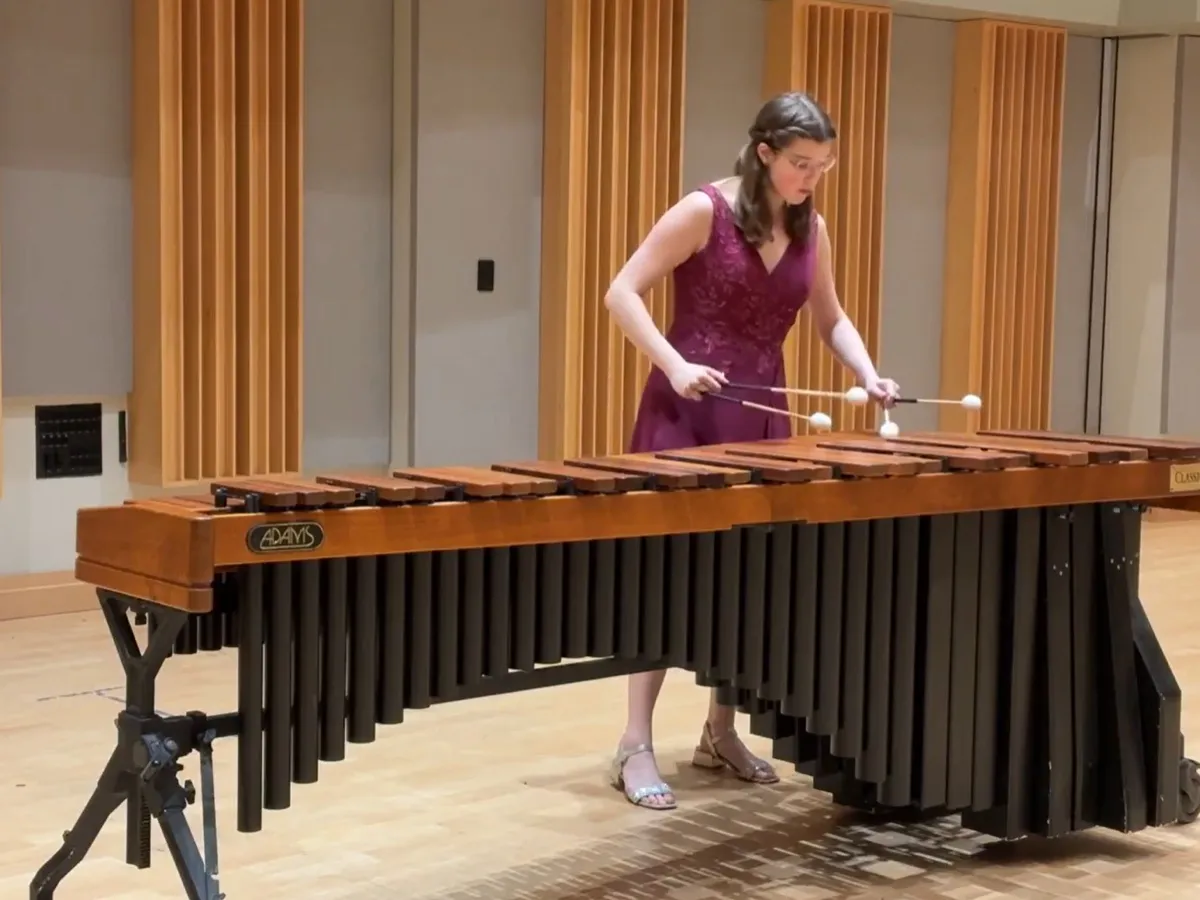 Liz Morad performing marimba in a plum gown