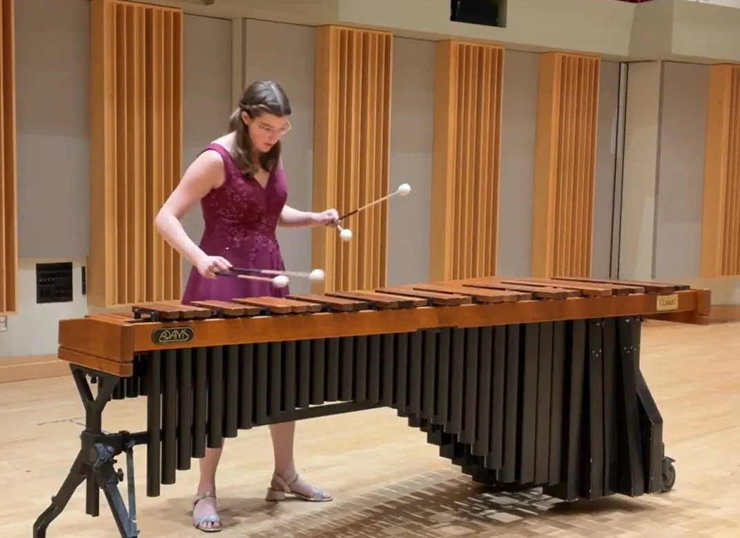 Liz Morad performing on marimba in a plum gown